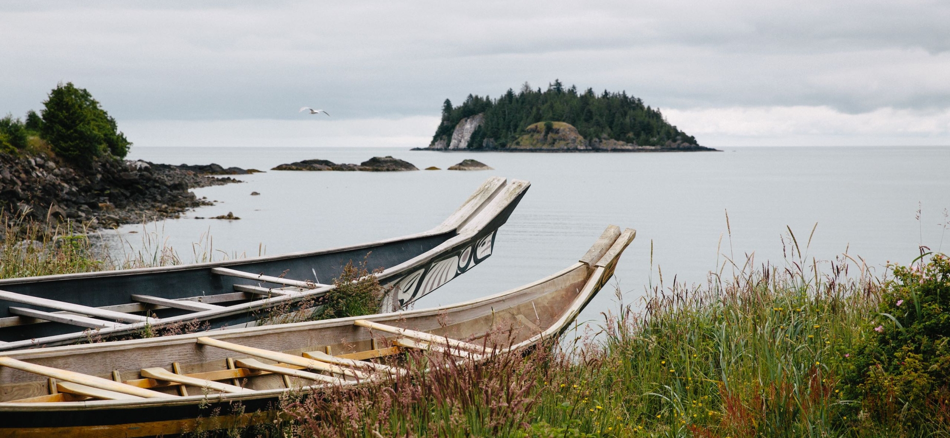 Haida canoes on the shoreline in front of the Haida Heritage Centre