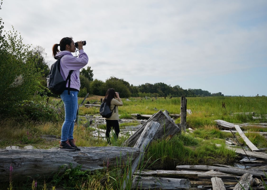 Two people bird watching and exploring Terra Nova Rural Park in Richmond.