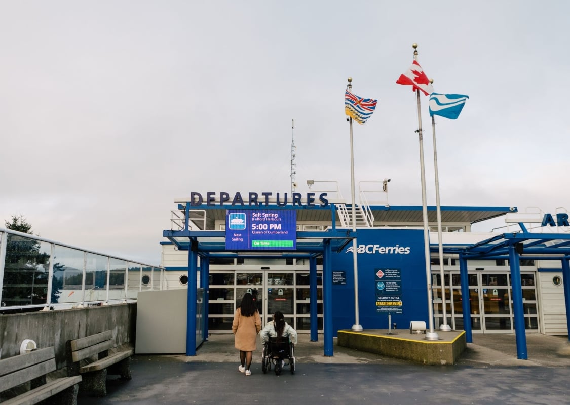 Two people entering the Ferry Terminal at Swartz Bay, including one wheelchair user, on Vancouver Island