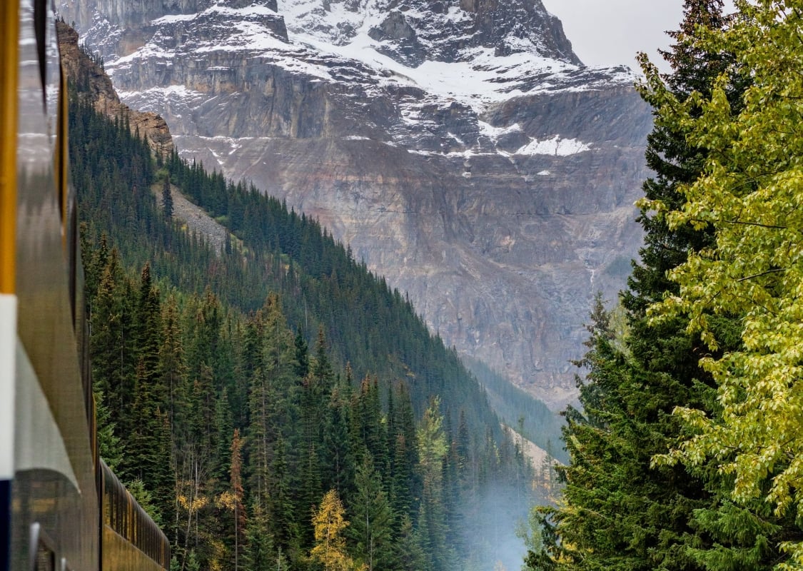 The Rocky Mountaineer train along side a mountain pass