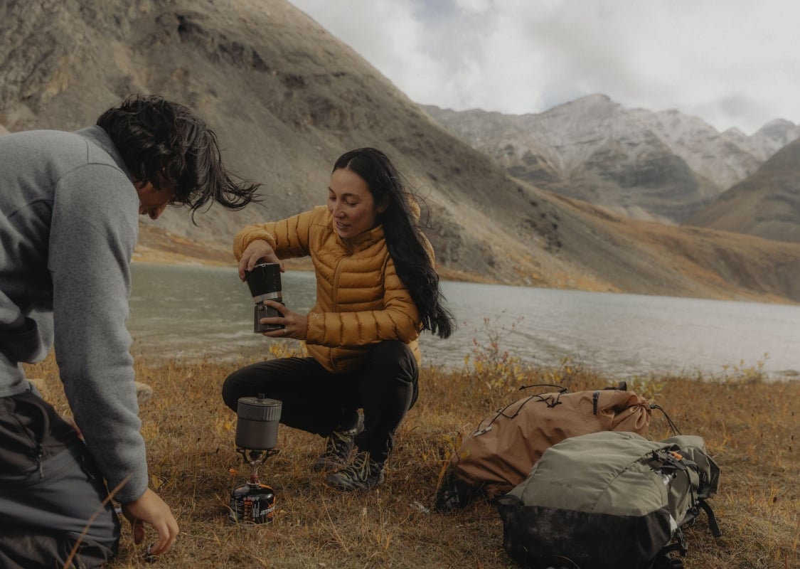 Two friends taking a coffee break during their hike along the Flowering Springs Trail in Stone Mountain Provincial Park in the Northern Rockies