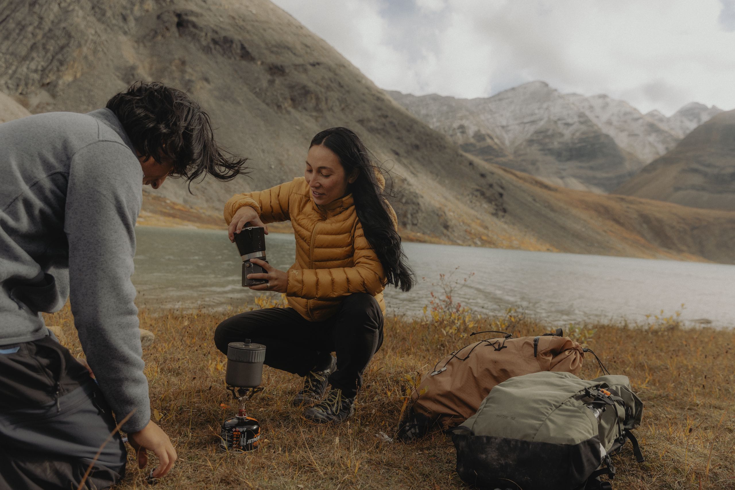 Two friends taking a coffee break during their hike along the Flowering Springs Trail in Stone Mountain Provincial Park in the Northern Rockies
