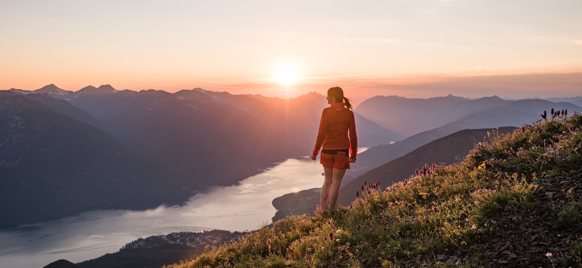 A hiker at the summit of the Idaho Peak Lookout overlooking Slocan Lake near New Denver, BC