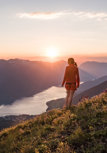 A hiker at the summit of the Idaho Peak Lookout overlooking Slocan Lake near New Denver, BC
