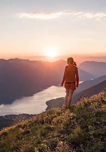 Ein*e Wander*in auf dem Gipfel des Idaho Peak Lookout mit Blick auf den Slocan Lake bei New Denver, BC