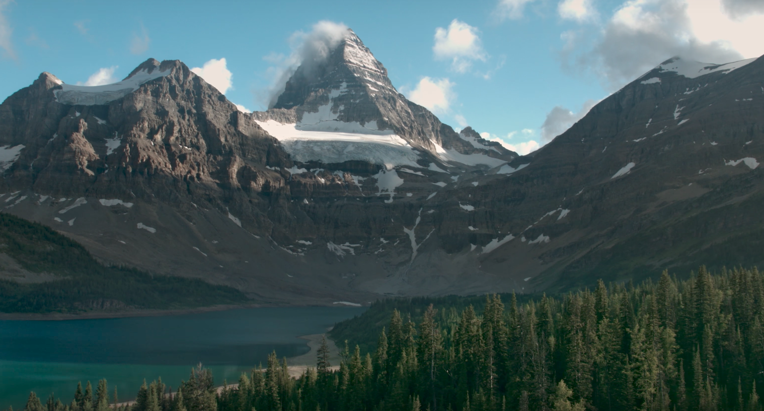 A snowy mountain with a lake at the bottom