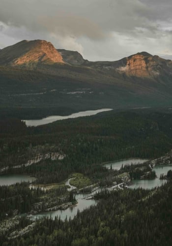 Una cordillera al atardecer en los Northern Rockies. Un río fluye por el valle.