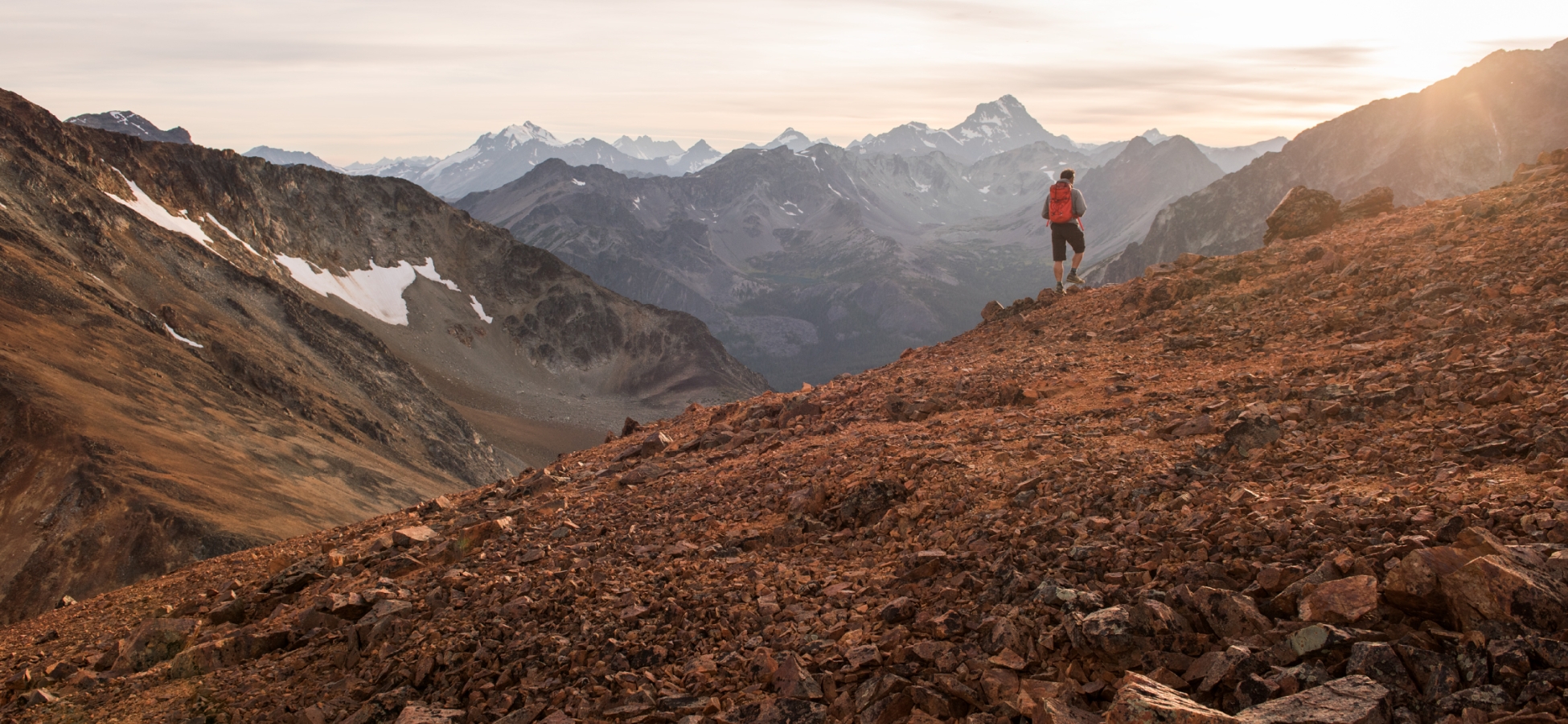 A hiker on a colourful ridge in the Niut Range, Coast Mountains, BC.