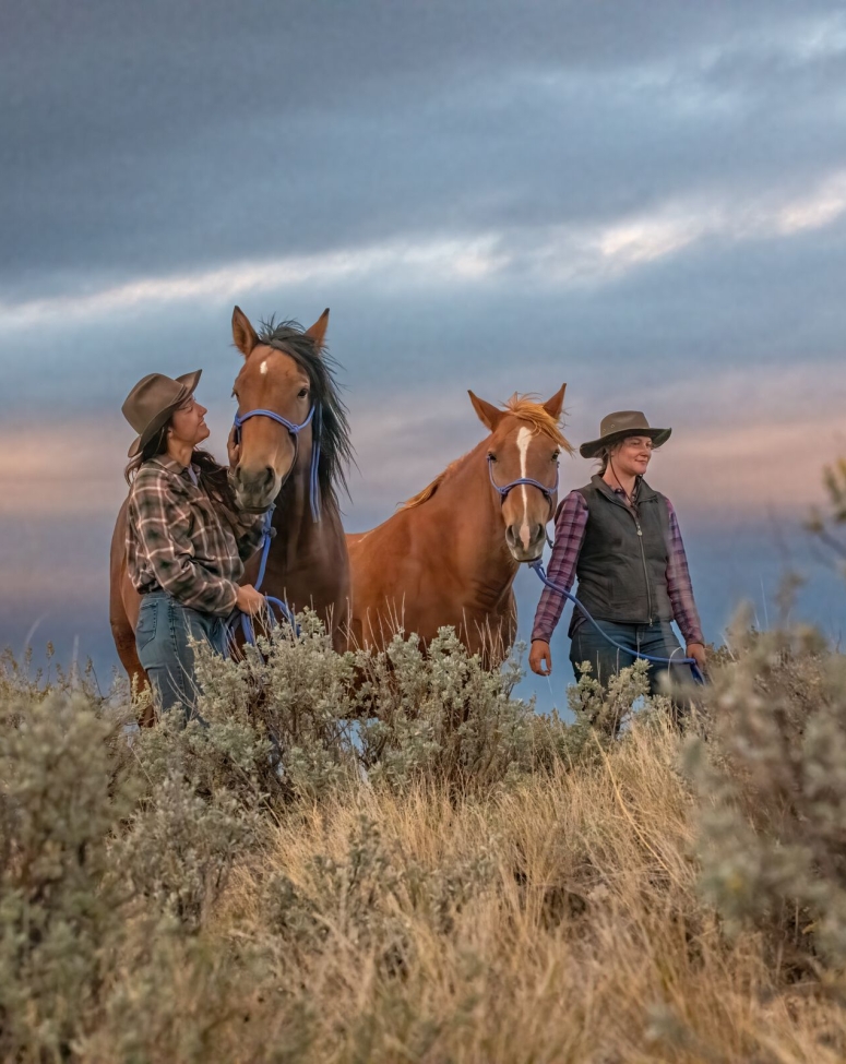 Two people walking together with horses at Sundance Guest Ranch in Ashcroft.