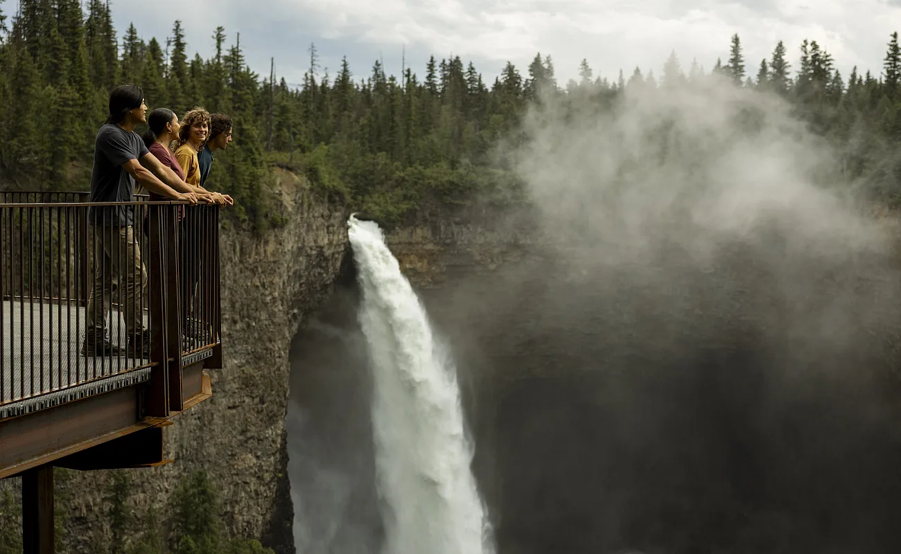 A group of friends enjoying the view of Helmcken Falls, Canada's fourth highest waterfall, from the viewing platform in Wells Gray Provincial Park, just a short walk from the parking lot.
