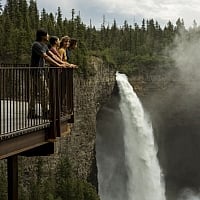 A group of friends enjoying the view of Helmcken Falls, Canada's fourth highest waterfall, from the viewing platform in Wells Gray Provincial Park, just a short walk from the parking lot.
