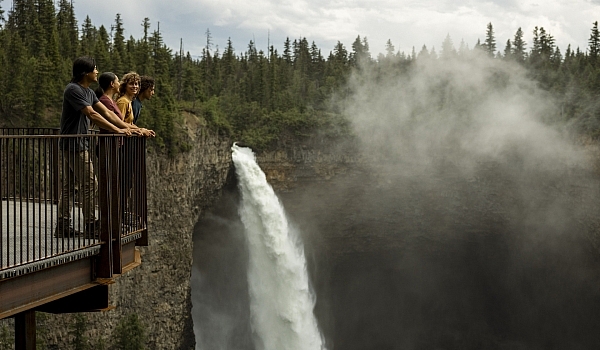 A group of friends enjoying the view of Helmcken Falls, Canada's fourth highest waterfall, from the viewing platform in Wells Gray Provincial Park, just a short walk from the parking lot.