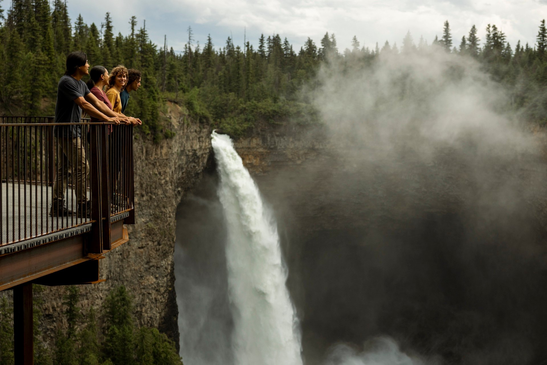 A group of friends enjoying the view of Helmcken Falls, Canada's fourth highest waterfall, from the viewing platform in Wells Gray Provincial Park, just a short walk from the parking lot.