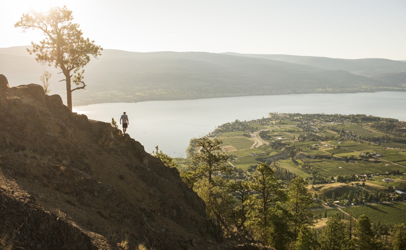 A hiker on Giant's Head Mountain with a view of Okanagan Lake