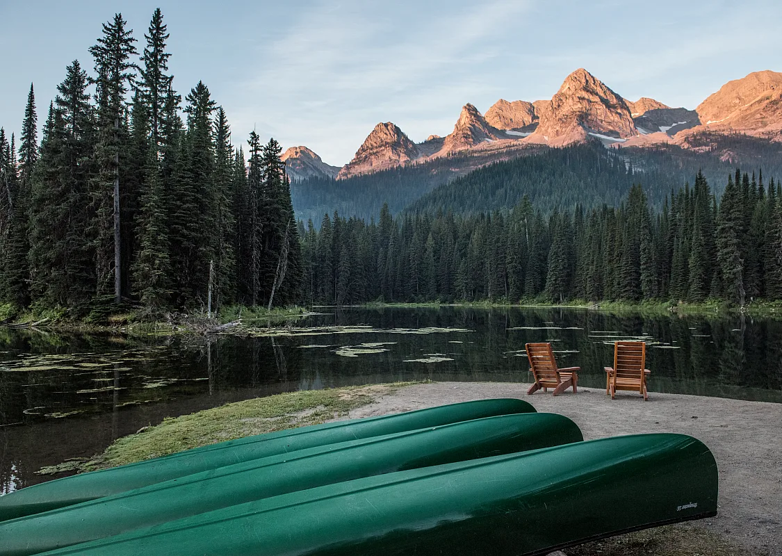 Canoas y asientos a la orilla del Island Lake cerca de Island Lake Lodge cerca de Fernie, BC