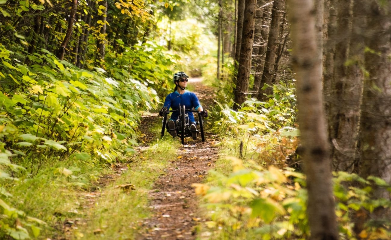 A hand-cyclist on the accessible Galena Trail in New Denver, BC.