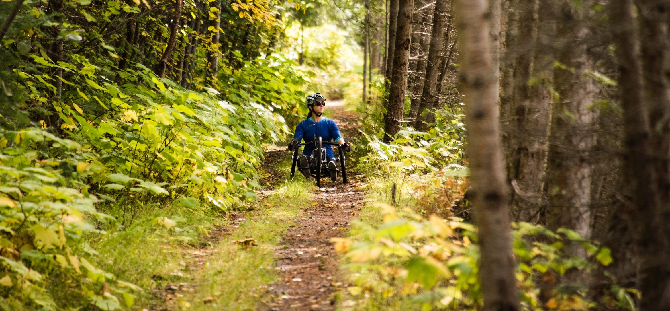 A hand-cyclist on the accessible Galena Trail in New Denver, BC.