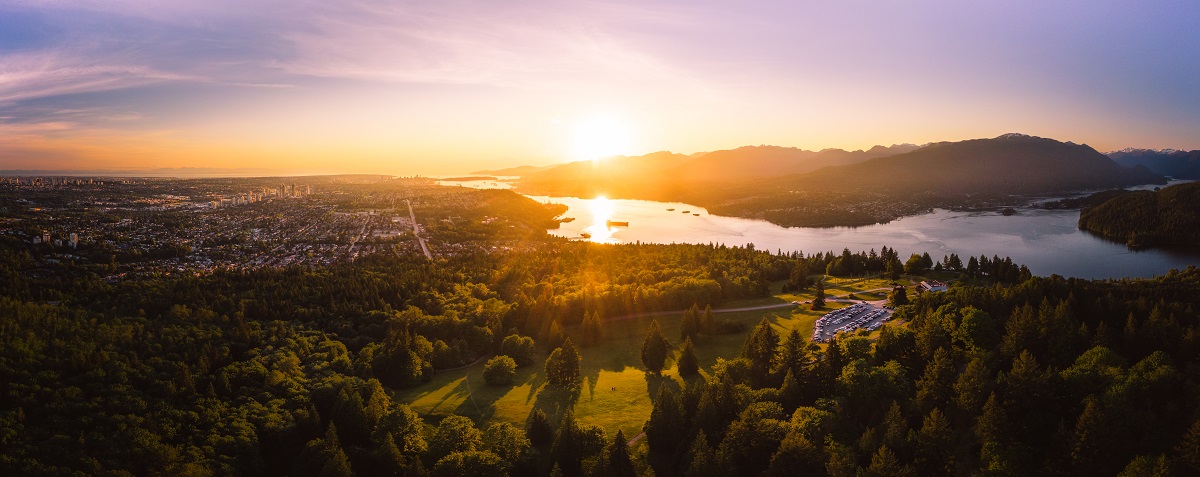 A sunset view from Burnaby Mountain, overlooking treetops extending into the horizon.