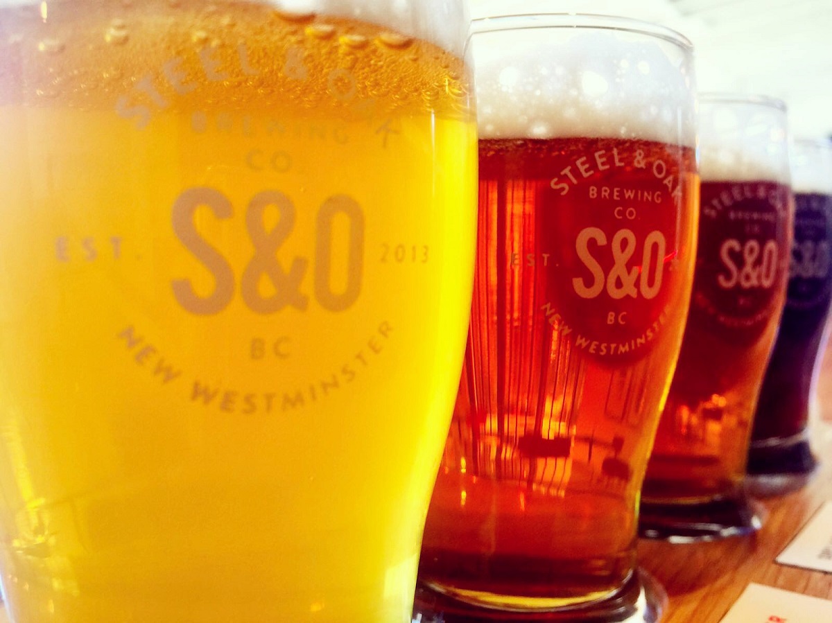 A row of various pints of beer ranging from light yellow to dark amber.