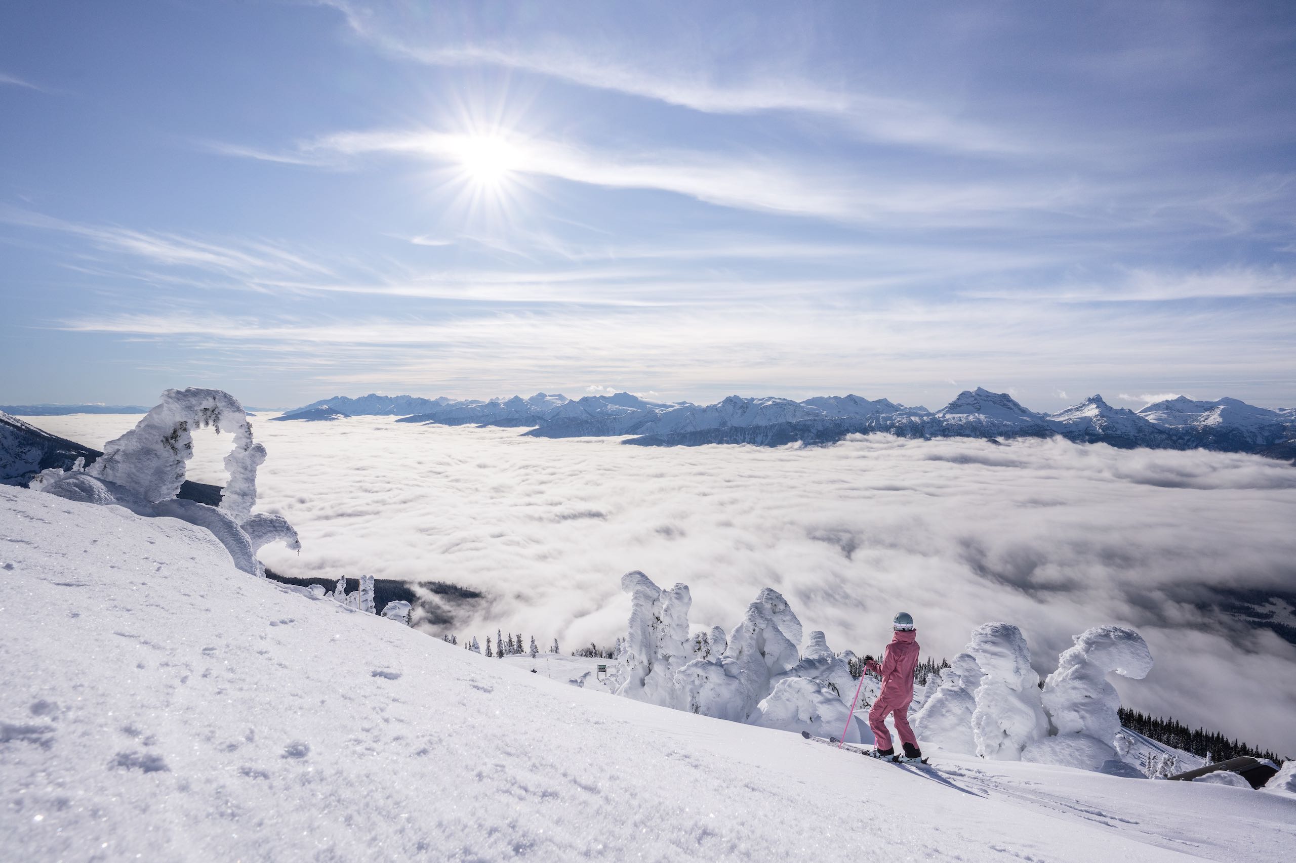 A woman taking a break from skiing to look out over the mountains