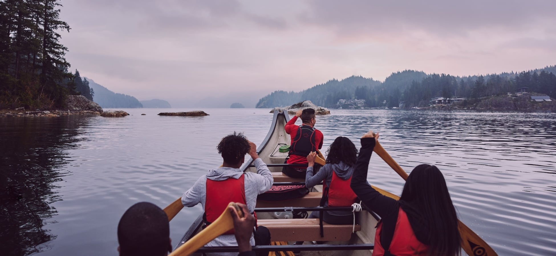 Eine Gruppe rudert mit Takaya Tours ein traditionelles Kanu der First Nations in Deep Cove.