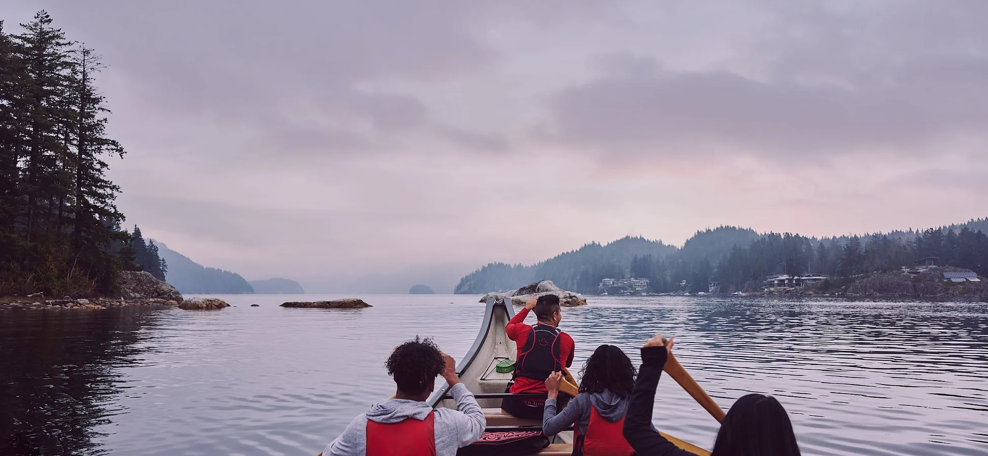 Un grupo con Takaya Tours, remando una canoa tradicional de las Primeras Naciones en Deep Cove.