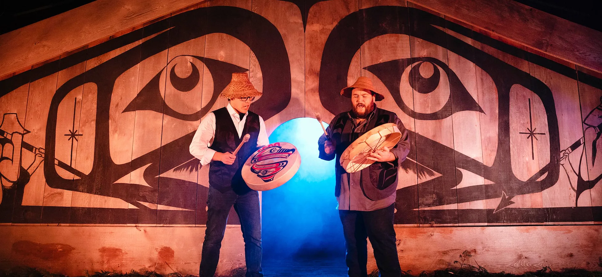 Dos personas tocando tambores en el escenario