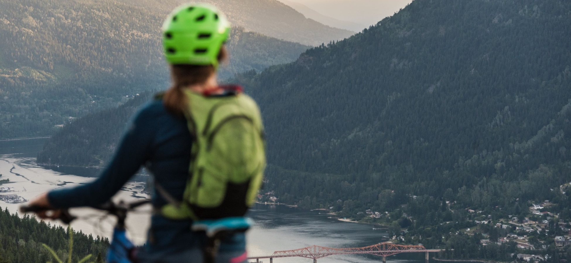A mountain biker on Log Jam Mountain Bike Trail overlooking Nelson, BC and Kootenay Lake