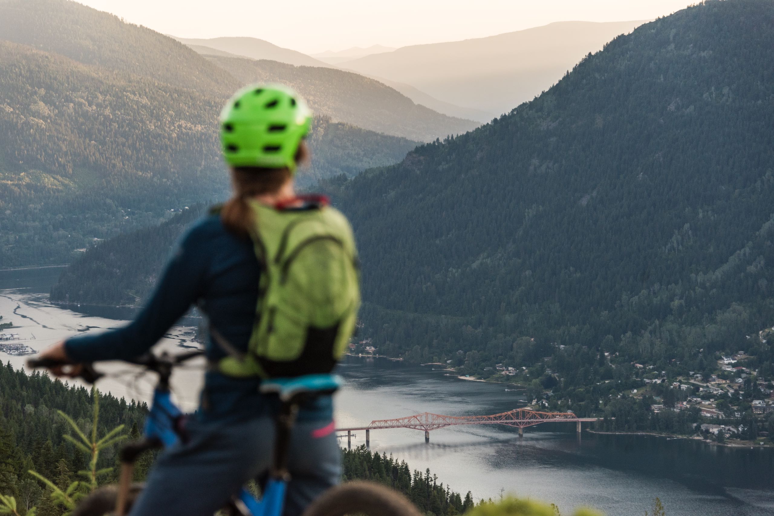 A mountain biker on Log Jam Mountain Bike Trail overlooking Nelson, BC and Kootenay Lake