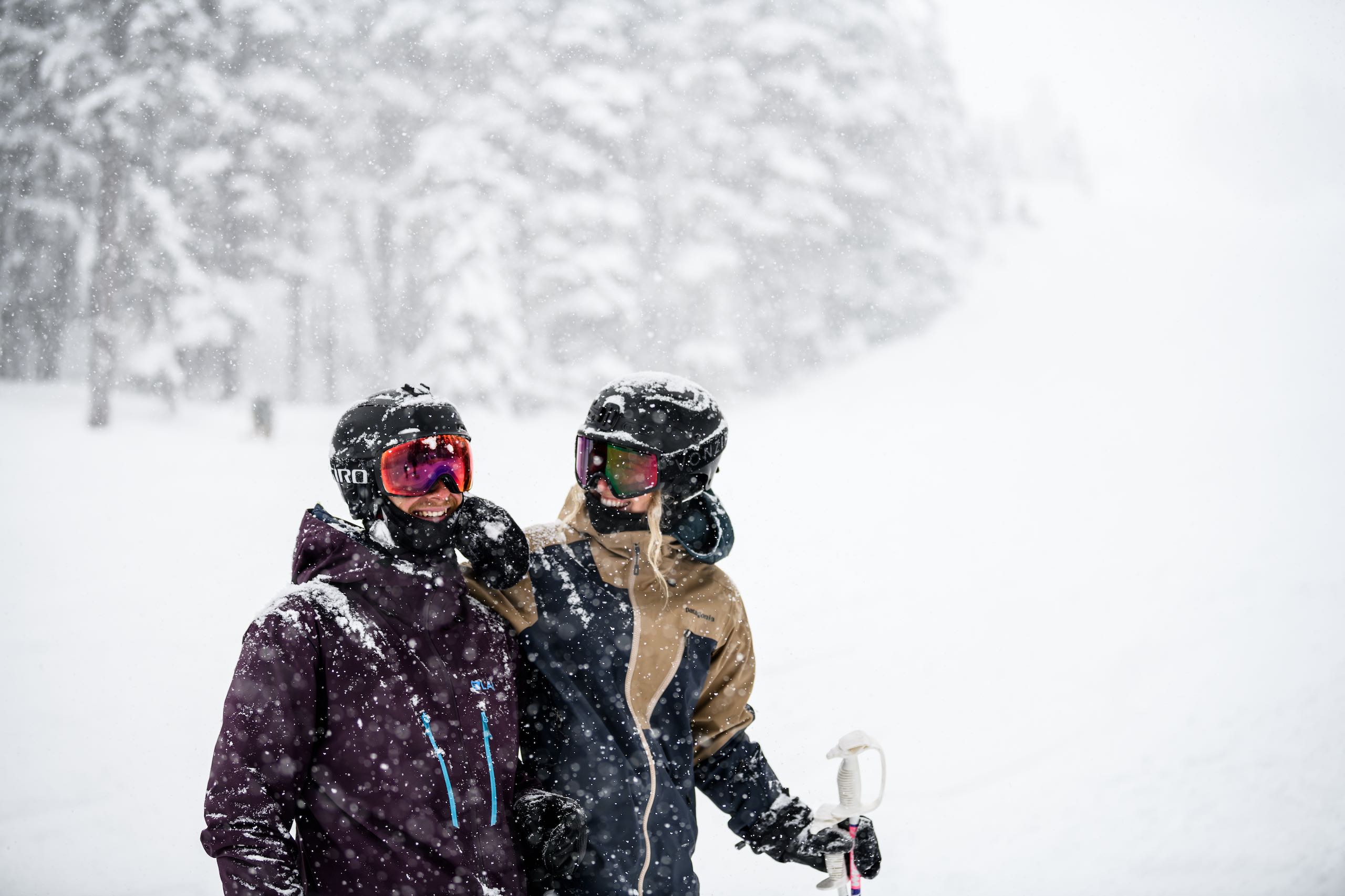 Two people enjoying the falling snow on Blackcomb Mountain in Whistler, BC.