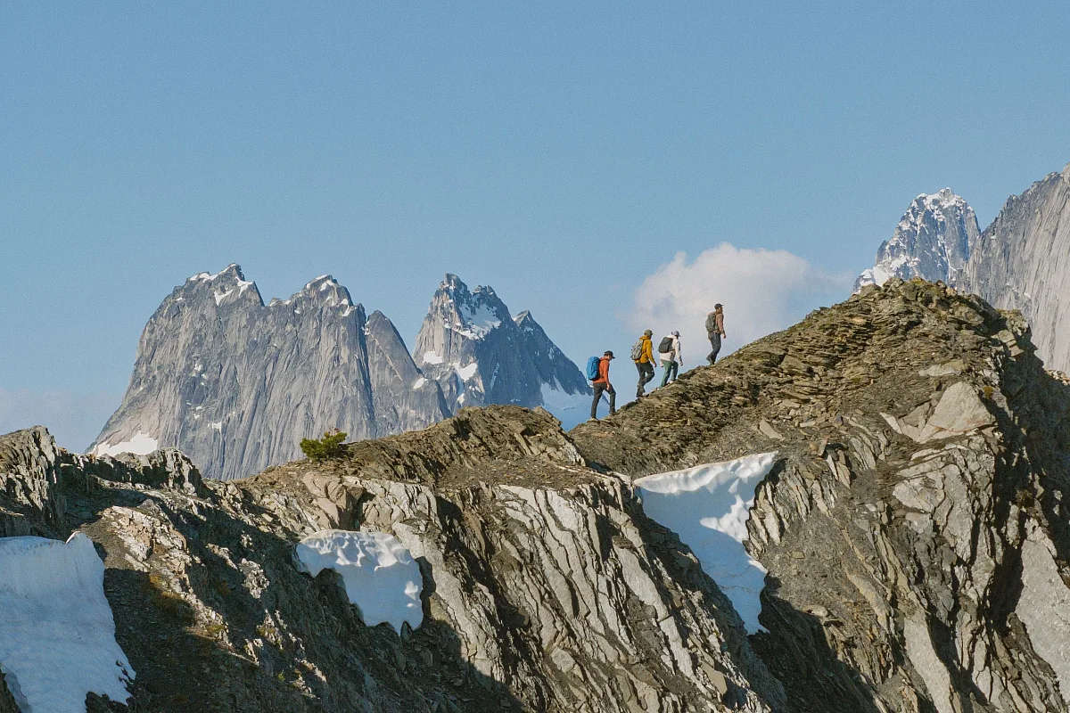 Tres amigos practicando heliesquí entre los glaciares y las agujas de las montañas de Bugaboos con su guía de CMH Bugaboos.