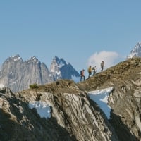 Three friends heli-hiking amongst the glaciers and mountain spires of the Bugaboos with their guide from CMH Bugaboos.