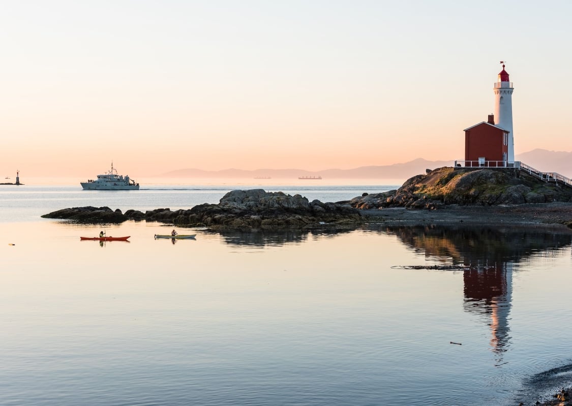 Personas en kayak cerca del Sitio Histórico Nacional del Faro de Fisgard