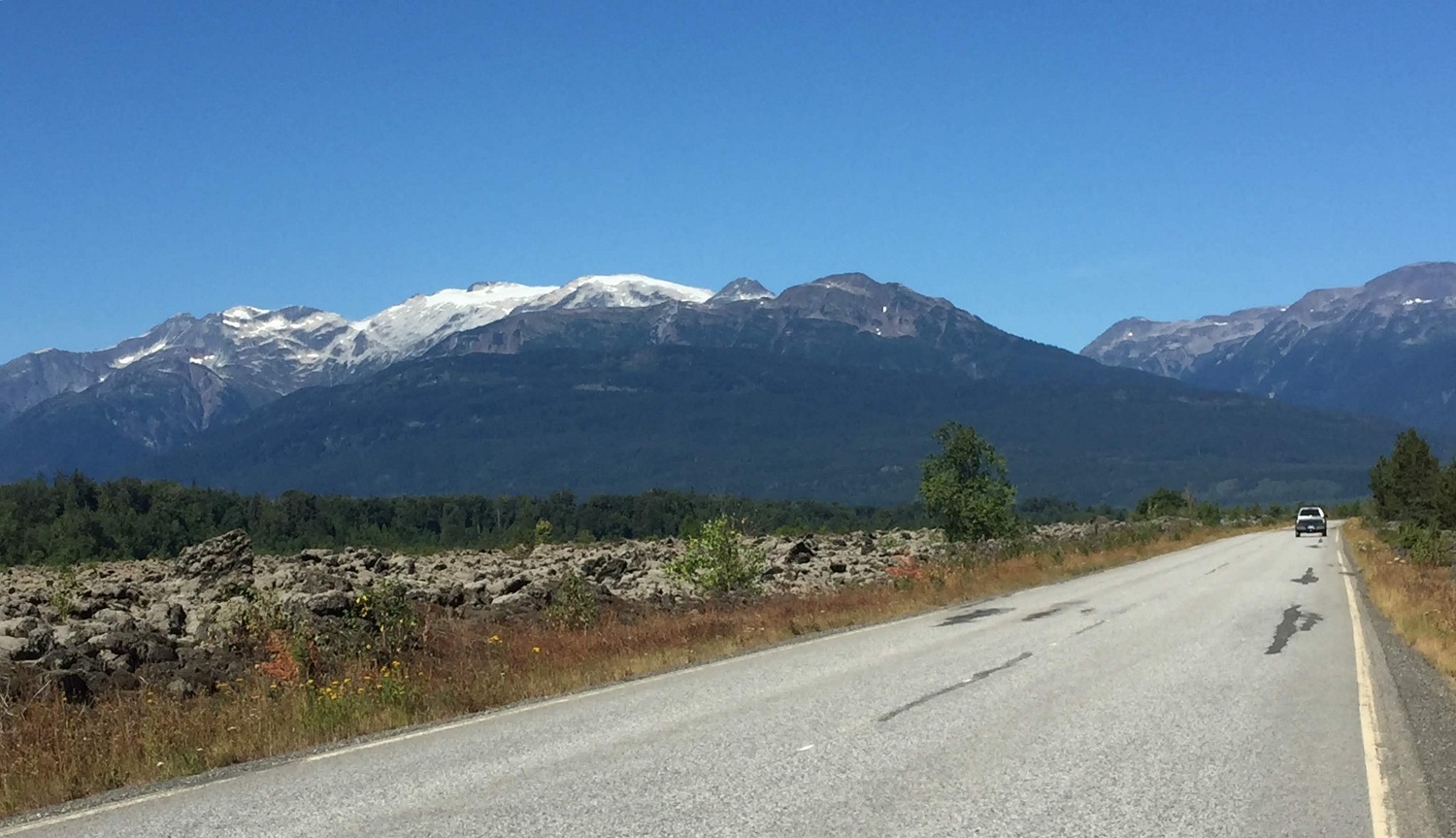 A long stretch of highway with a mountain in the distance