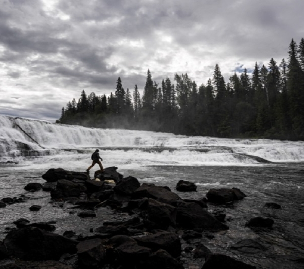 Person walking on rocks by a river