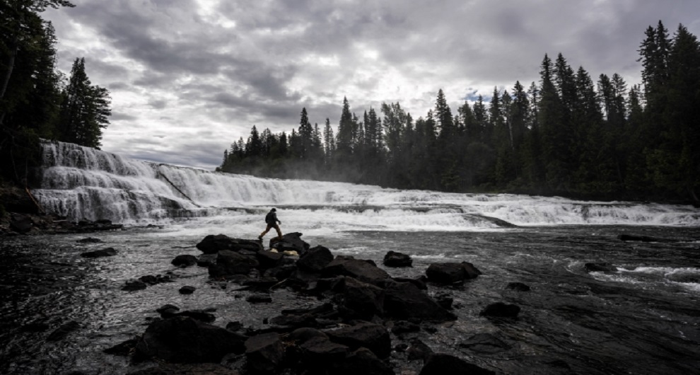 Person walking on rocks by a river