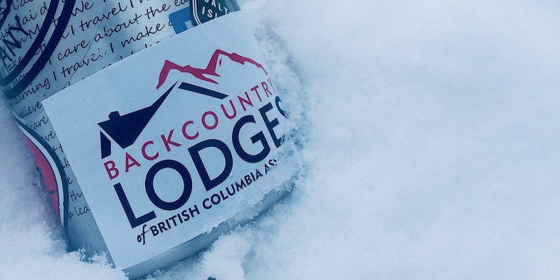 Backcountry Lodges of British Columbia logo on a water bottle in the snow.