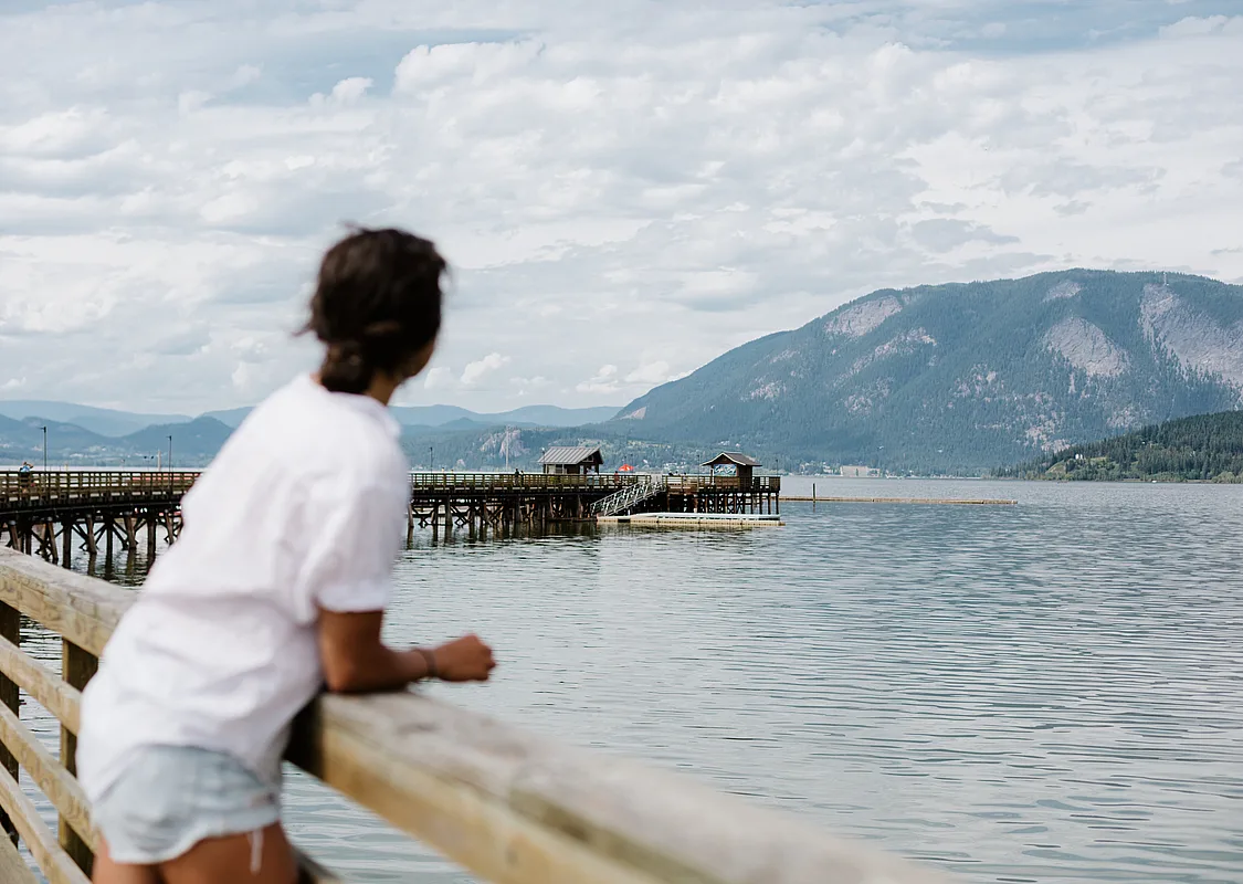 A woman looks out from the Salmon Arm Wharf to the water.