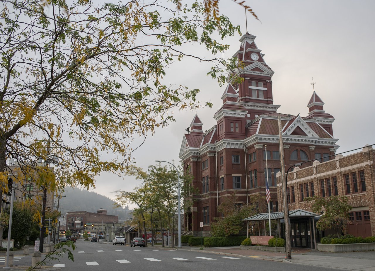 View down a tree-lined city street with historic buildings.