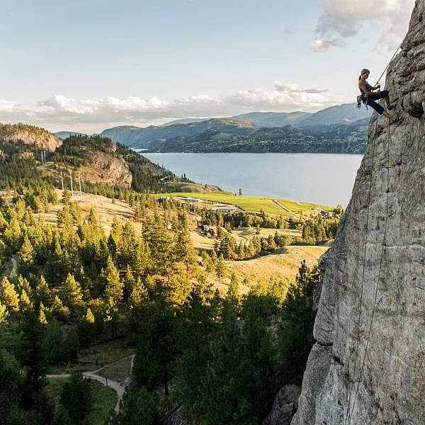 A rock climber rappels from the route Plumb Line on The Fortress with a view of Skaha Lake near Penticton | Kari Medig