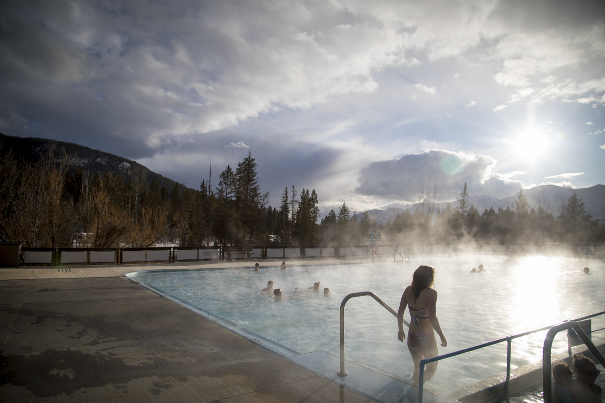 A women walks into the Fairmont Hot Springs. Mist comes off the pool obscuring the other bathers.