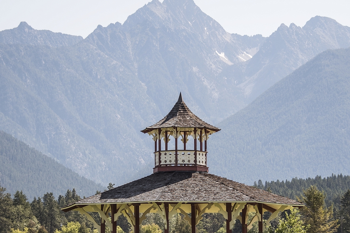 Children run in front of the gazebo at Fort Steele, a heritage town near Cranbrook BC. Mount Fisher in the background.