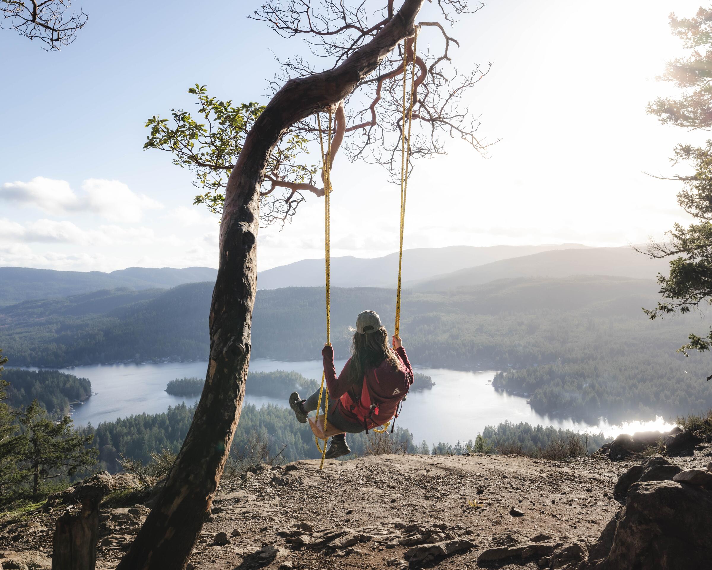 A hiker taking a moment to enjoy the view from a swing on Old Bay Mountain in Shawnigan Lake on Vancouver Island.