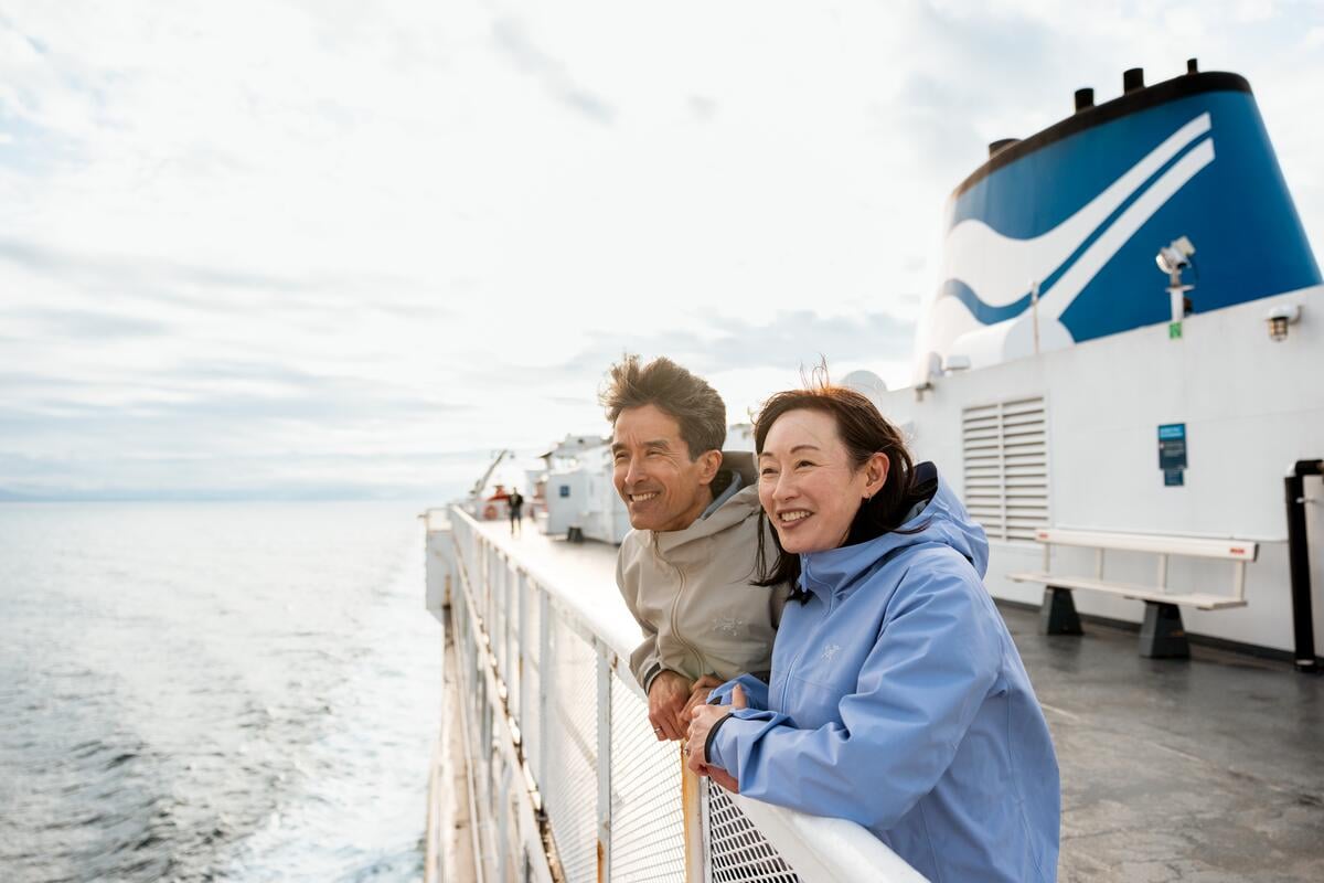 A couple enjoying their view of the Salish Sea onboard a BC Ferries vessel heading from Horseshoe Bay in West Vancouver to Departure Bay in Nanaimo on Vancouver Island.