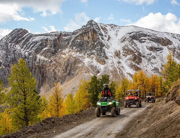 ATV & SXS tour through the spectacular Paradise Basin larch forest on a dirt path in Panorama on a clear fall day.