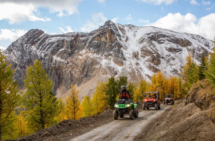 ATV & SXS tour through the spectacular Paradise Basin larch forest on a dirt path in Panorama on a clear fall day.