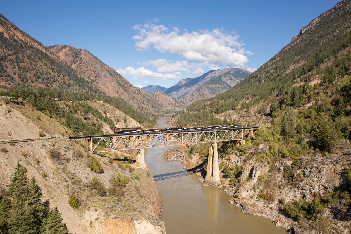 A train crosses a bridge over a river valley.