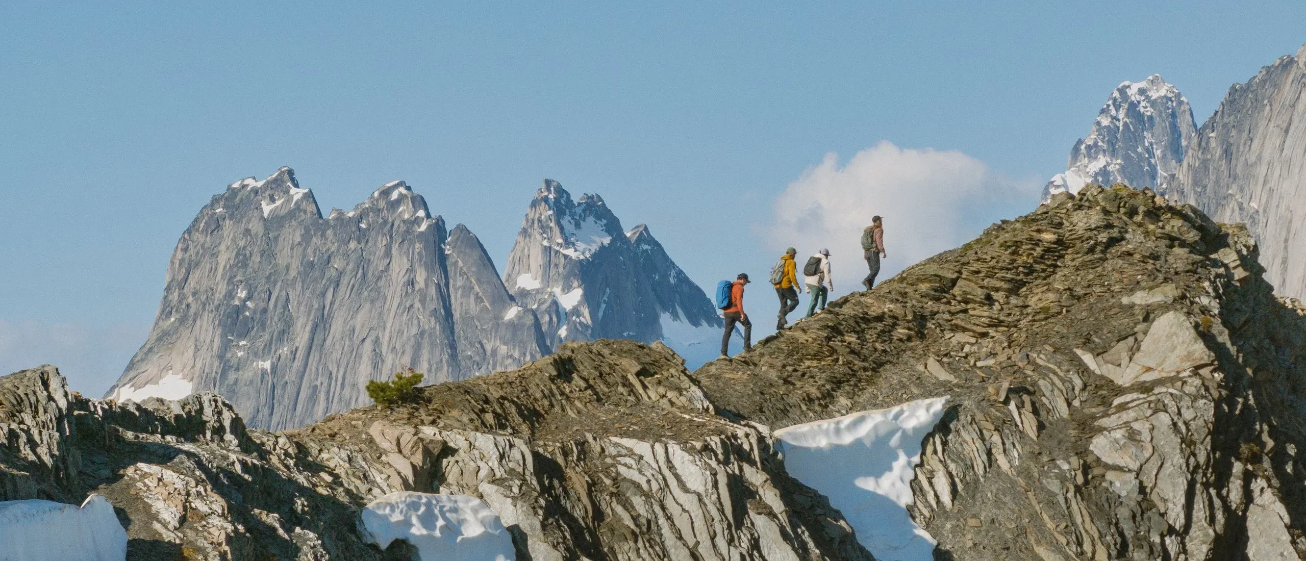 Three friends heli-hiking amongst the glaciers and mountain spires of the Bugaboos with their guide from CMH Bugaboos.