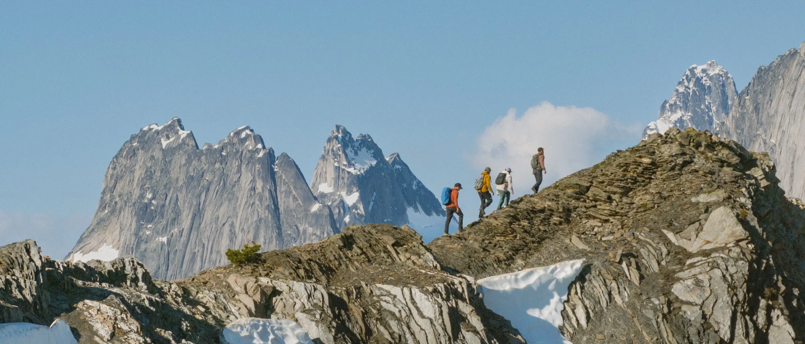 Three friends heli-hiking amongst the glaciers and mountain spires of the Bugaboos with their guide from CMH Bugaboos.