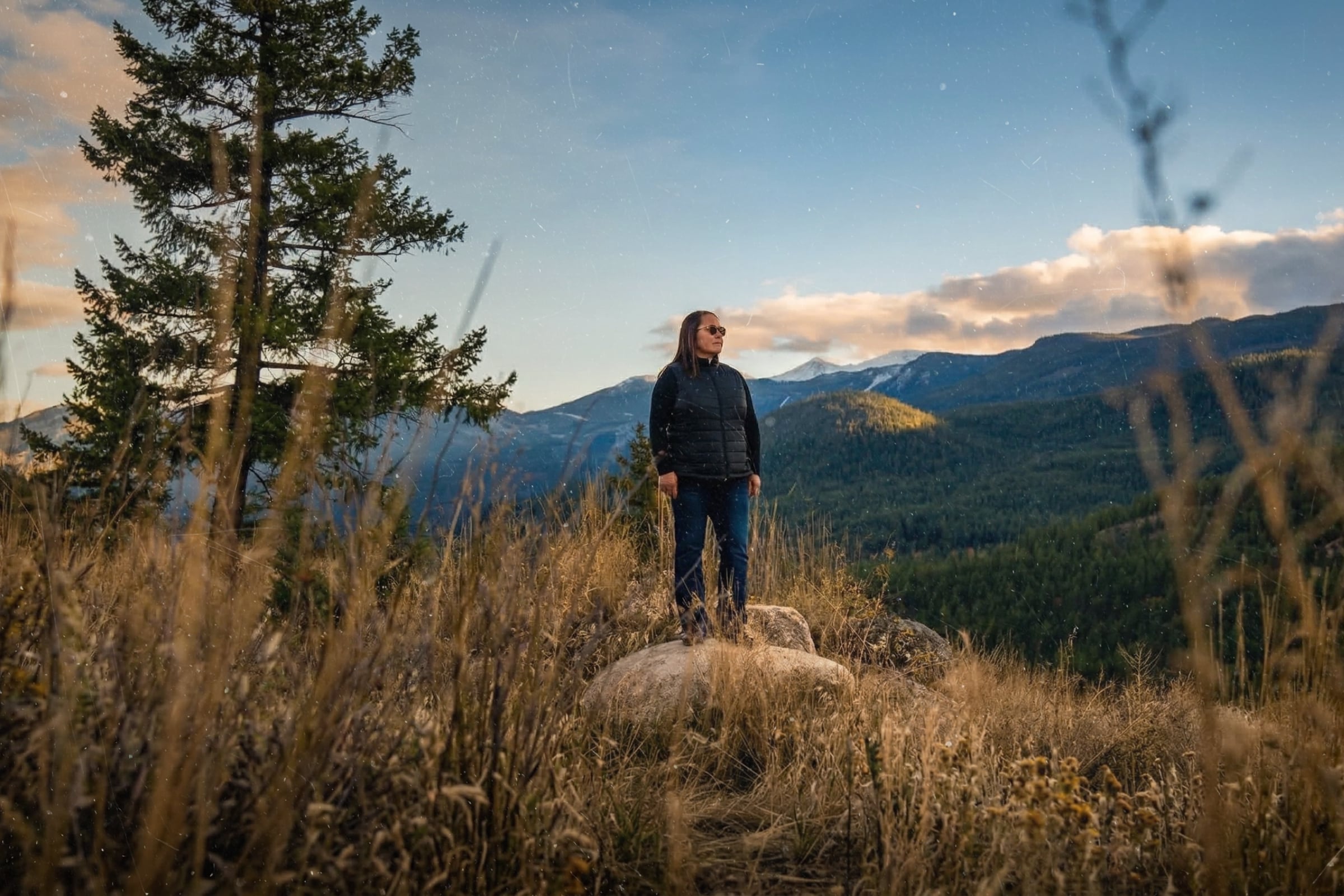 una persona de pie al aire libre con las montañas al fondo